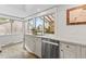 Well-lit kitchen featuring stainless steel dishwasher, marble countertops, wooden floors, and a window view to outside at 2867 S Oswego Ct, Aurora, CO 80014
