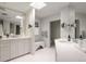 Bright bathroom featuring dual vanity, a skylight, and white honeycomb tile flooring at 450 Steele St, Denver, CO 80206