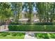 Charming two-story home with manicured lawn, black metal fence, and mature trees at 450 Steele St, Denver, CO 80206