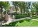 Charming two-story home with manicured lawn, brick entryway, black metal fence, and privacy hedge at 450 Steele St, Denver, CO 80206