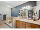 Bright bathroom featuring a soaking tub, granite countertops, a walk-in shower, and neutral-colored tiles at 25357 Snyder Ave, Conifer, CO 80433