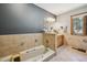 This primary bathroom offers neutral tiles, a soaking tub, granite countertops, and a large window view at 25357 Snyder Ave, Conifer, CO 80433
