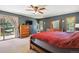 Cozy primary bedroom with a wood-burning stove, deck access, and outdoor views at 25357 Snyder Ave, Conifer, CO 80433