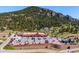 An eye-level, elevated view of a commercial building and parking lot at the foot of a mountain at 25357 Snyder Ave, Conifer, CO 80433