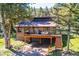 Two-story home with two-car garage and a large deck with furniture perfect for entertaining at 25357 Snyder Ave, Conifer, CO 80433