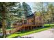 Charming brick home with a spacious deck surrounded by lush greenery at 25357 Snyder Ave, Conifer, CO 80433