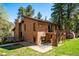 Charming two-story brick home with a deck and lush green yard surrounded by mature trees at 25357 Snyder Ave, Conifer, CO 80433