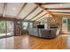 Inviting living room featuring a stone fireplace, beamed ceiling, and hardwood floors at 25357 Snyder Ave, Conifer, CO 80433