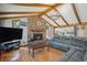 Comfortable living room with stone fireplace, vaulted ceiling, and hardwood floors at 25357 Snyder Ave, Conifer, CO 80433