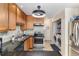 Well-maintained kitchen featuring wood cabinetry, stainless steel appliances, and tile flooring at 11917 Monroe St, Thornton, CO 80233