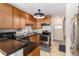 Functional kitchen featuring wood cabinets, stone countertops, stainless appliances and tile floors at 11917 Monroe St, Thornton, CO 80233