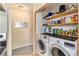 Convenient laundry area with washer, dryer, and shelving for storage at 11917 Monroe St, Thornton, CO 80233