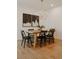 Modern dining room with hardwood floors, a wooden table and black chairs, abstract artwork, and chandelier at 527 Fox St, Denver, CO 80204