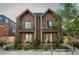 Brick two-story home featuring a small black metal fenced yard and a balcony with neutral-colored pots at 527 Fox St, Denver, CO 80204