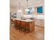 Modern kitchen featuring hardwood floors, an island with barstools and pendant lights, and stainless steel appliances at 527 Fox St, Denver, CO 80204
