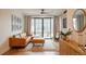 Cozy living room featuring a brick fireplace, leather couch, a modern ceiling fan, and large windows at 527 Fox St, Denver, CO 80204