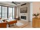 Cozy living room featuring a brick fireplace, leather couch, a modern ceiling fan, and large windows at 527 Fox St, Denver, CO 80204