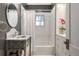 Well lit bathroom with marble sink, white tile and shower/tub combo at 4535 E Montview Blvd, Denver, CO 80207
