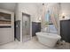 Bright bathroom featuring a soaking tub, glass-enclosed shower, and stylish fixtures at 4535 E Montview Blvd, Denver, CO 80207