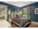 Stylish bedroom with a striking blue accent wall, hardwood floors, and a decorative headboard at 4535 E Montview Blvd, Denver, CO 80207