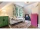 Bright bedroom featuring an area rug, a single bed, colorful curtains, and a cozy armchair at 4535 E Montview Blvd, Denver, CO 80207