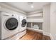 Efficient laundry room features side-by-side washer and dryer with storage shelves at 4535 E Montview Blvd, Denver, CO 80207