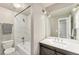 Updated bathroom featuring a marble-tiled shower, a modern vanity with a large mirror and stylish lighting at 2179 Sunridge Cir, Broomfield, CO 80020