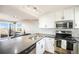 Modern kitchen featuring stainless steel appliances, white cabinets, and a breakfast bar overlooking the dining area at 2179 Sunridge Cir, Broomfield, CO 80020