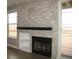 Charming living room featuring a stone fireplace, dark mantle, built-in shelving and sliding glass door to the back deck at 2179 Sunridge Cir, Broomfield, CO 80020