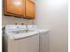 Bright laundry room with LG washer and dryer and wood cabinets at 2115 Coronado Pkyn # B, Denver, CO 80229