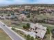 Aerial view of an estate showcasing the custom home, landscaping, and surrounding mountainous terrain at 7952 Dante Dr, Littleton, CO 80125