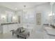 Bright bathroom with a standalone tub, double vanity, hexagon tile, and elegant lighting fixtures at 7952 Dante Dr, Littleton, CO 80125