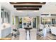 Open dining room showcasing wood beams, floors, and access to the balcony at 7952 Dante Dr, Littleton, CO 80125