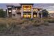 Expansive stone home with multiple balconies overlooking landscaped grounds at sunset at 7952 Dante Dr, Littleton, CO 80125