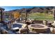 Inviting outdoor patio area with comfortable seating, a fire pit, and golf course views at 7952 Dante Dr, Littleton, CO 80125
