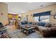 Inviting living room features a large sectional sofa and hardwood floors leading to an open concept kitchen area at 19707 E 59Th Pl, Aurora, CO 80019