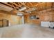 Spacious garage interior featuring exposed wood beam ceiling, concrete flooring, and ample storage at 762 S Paddock St, Elizabeth, CO 80107