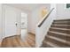Inviting entryway with wood floors, a white front door, and staircase leading to the upper level of the home at 190 Lark Sparrow Way, Bennett, CO 80102