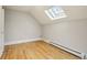Minimalist bedroom with a skylight, hardwood floors, and fresh white walls at 2255 18Th St, Boulder, CO 80302