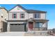 Two-story house with gray siding, red shutters, and a gray three-car garage at 18344 Prince Hill Cir, Parker, CO 80134