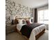 Stylish bedroom with a modern bed, unique accent wall, and natural light from the window at 6153 N Ceylon St # 104, Denver, CO 80249