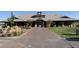 Inviting clubhouse exterior featuring stone accents, a brick-paved entrance, and well-manicured landscaping at 6153 N Ceylon St # 104, Denver, CO 80249