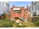 Charming backyard with classic brick home and wooden stairs leading to a unique porch entrance at 2914 W 29Th Ave, Denver, CO 80211