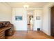 Bright living room featuring gleaming hardwood floors and an antique secretary desk, framed by white walls at 2914 W 29Th Ave, Denver, CO 80211