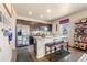 Well-lit kitchen showcasing a breakfast bar with stool seating and modern stainless steel refrigerator at 13673 Valentia St, Thornton, CO 80602