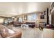 Spacious living room featuring plush seating, a large window, and a view of the adjacent dining and kitchen areas at 13673 Valentia St, Thornton, CO 80602