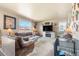 Cozy living room filled with comfortable furniture, natural light, and a fireplace at 13673 Valentia St, Thornton, CO 80602