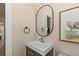 Chic powder room with a sleek vessel sink, oval mirror, and charming elephant artwork at 2233 Kipling St, Lakewood, CO 80215