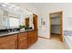 Bright and spacious bathroom with double sinks, granite counters, and a view of the tub and shower at 10273 Nottingham Dr, Parker, CO 80134