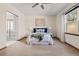 Bright bedroom featuring a ceiling fan, a comfortable bed, and an attached bathroom at 10273 Nottingham Dr, Parker, CO 80134